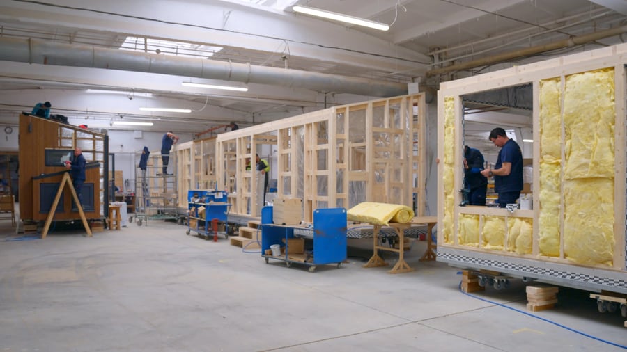 Mitarbeiter bedient eine große Produktionsmaschine in der DWELLII Werkhalle