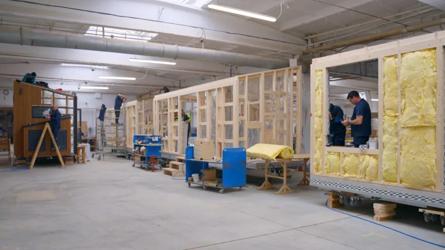 Mitarbeiter bedient eine große Produktionsmaschine in der DWELLII Werkhalle