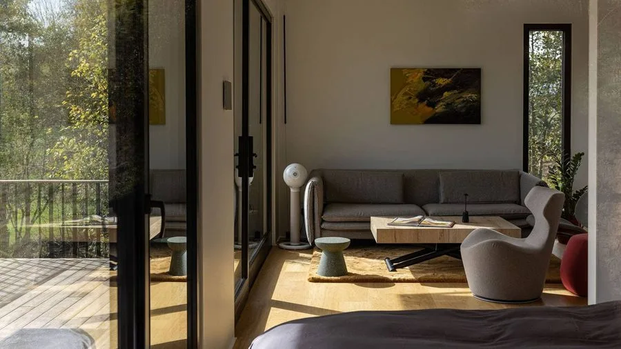 View through the open glazing into the TR01 bedroom with bed and artwork on the wall