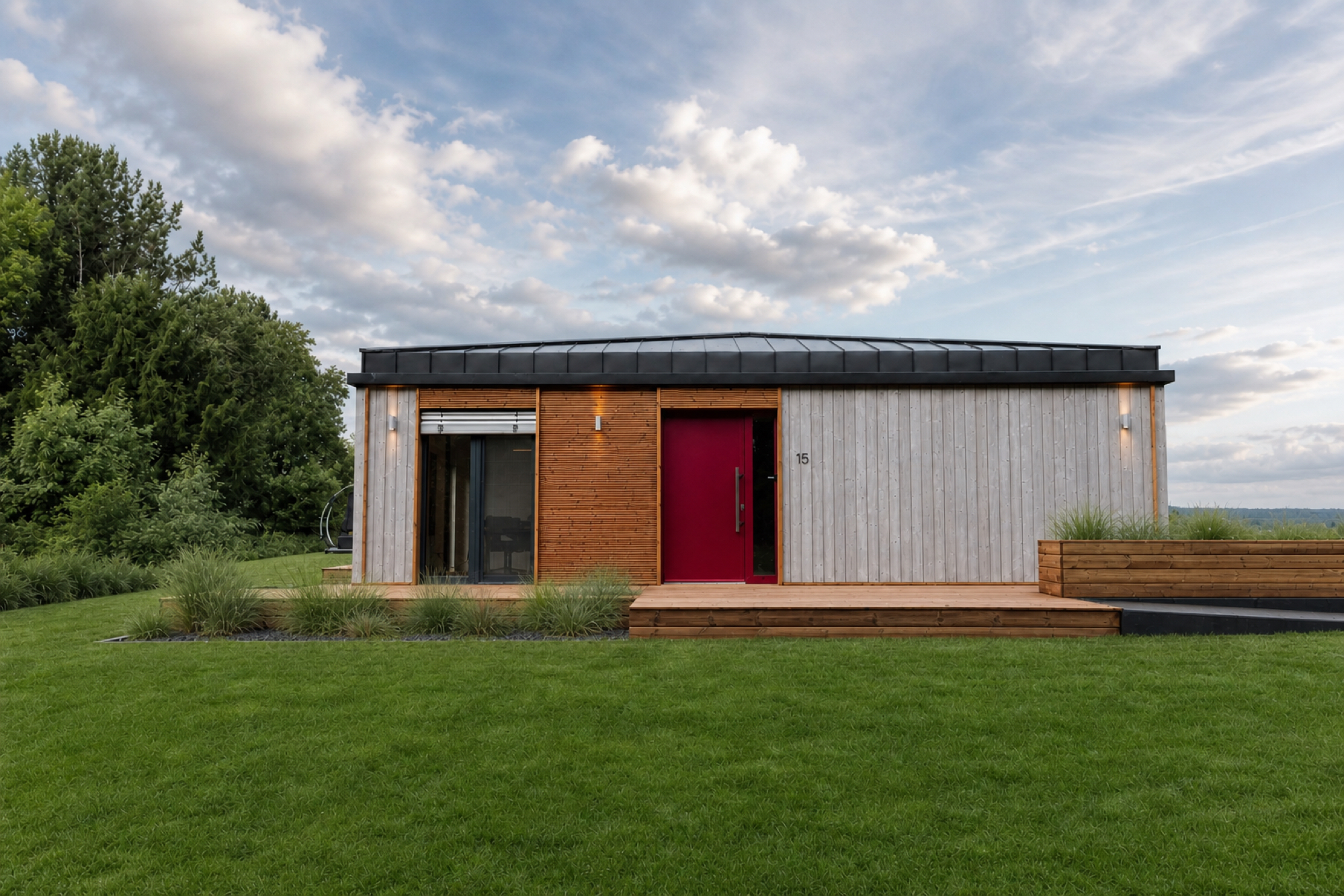 Gartenfassade des Musterhauses TR3M auf weiter Rasenfläche, rote Eingangstür, großer Himmel mit Wolken
